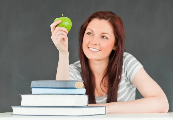 Jovem estudante em uma sala de aula olhando para uma maçã — Fotografia de Stock