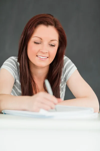 Retrato de una hermosa joven estudiante tomando notas — Foto de Stock