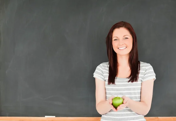 Piękna młoda kobieta trzyma jabłko z tablicy — Zdjęcie stockowe
