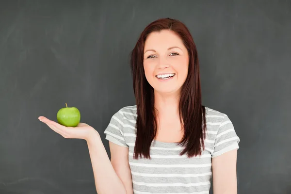 Jonge vrouw met een appel op haar palm — Stockfoto