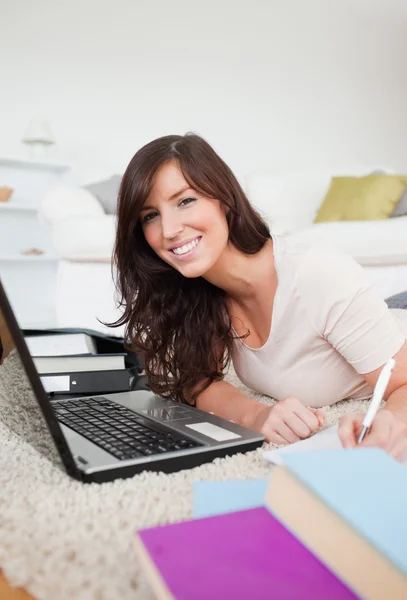 Junge brünette Frau entspannt mit ihrem Laptop und posiert, während w — Stockfoto