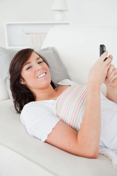 Krásná bruneta žena psaní textu na její mobil — Stock fotografie