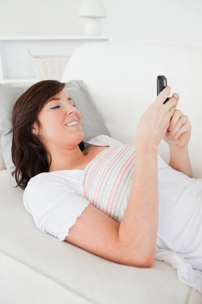 Pretty brunette female writing a text on her mobile — Stock Photo, Image