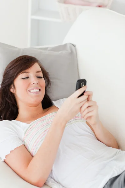 Okouzlující bruneta žena psaní textu na její mobil — Stock fotografie