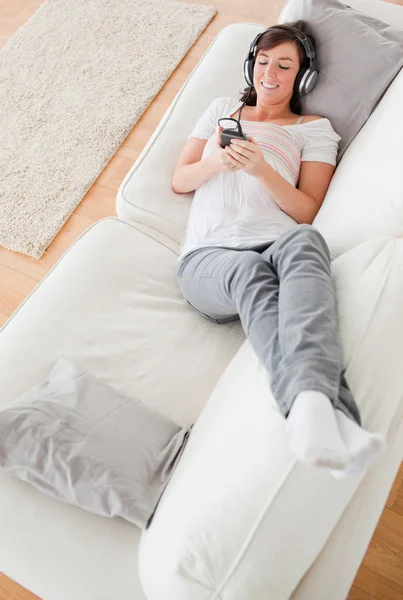 Piękna brunetka kobieta na telefon leżąc na kanapie — Zdjęcie stockowe