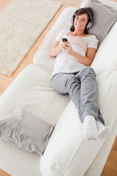 Atrakcyjny brunetka dama na telefon leżąc na kanapie — Zdjęcie stockowe
