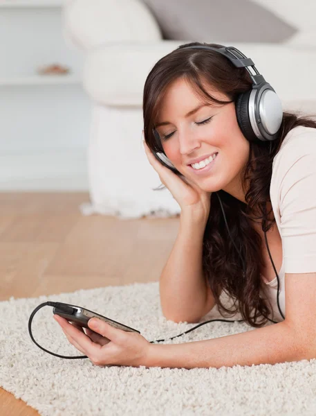 Mooie brunette vrouw luisteren naar muziek met haar mp3 whi — Stockfoto