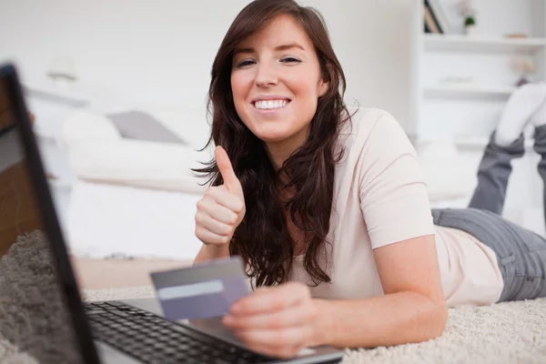 Ung söt kvinna att göra en betalning med kreditkort på integ — Stockfoto