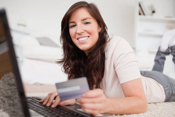 Jovem bonita fêmea fazendo um pagamento com um cartão de crédito em — Fotografia de Stock