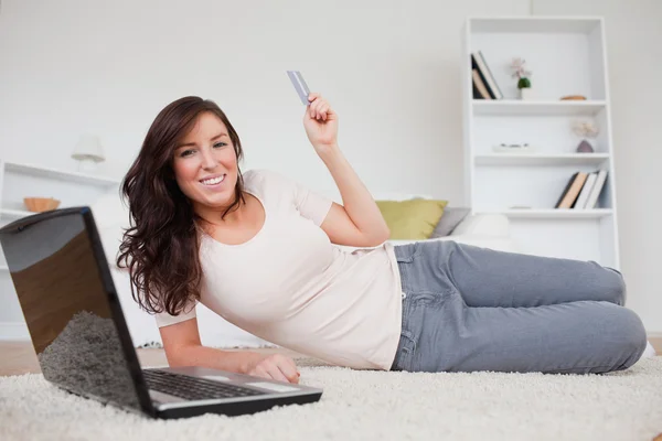 Lockande brunett kvinna att göra en betalning med kreditkort o — Stockfoto