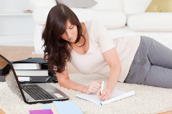Ung attraktiv kvinna avkopplande med sin laptop när du skriver på — Stockfoto