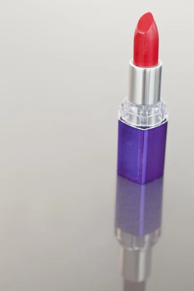 Retrato de un lápiz labial con un tubo púrpura — Foto de Stock