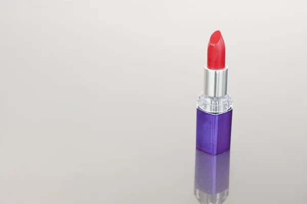 Lápiz labial rojo con tubo púrpura — Foto de Stock