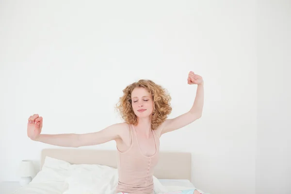 Gorgeous blonde female stretching in her bedroom — Stock Photo, Image