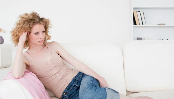 Atrakcyjny blond kobieta relaksujący siedząc na kanapie — Zdjęcie stockowe