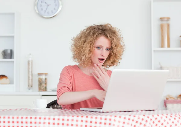Atrakcyjny blond kobieta relaksując się przy jej laptopa siedząc — Zdjęcie stockowe
