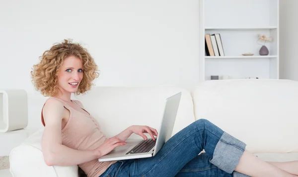 stock image Good looking blonde woman relaxing with her laptop while sitting