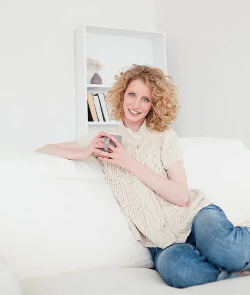 Przepiękny blond kobieta cieszyć się filiżanką kawy siedząc — Zdjęcie stockowe