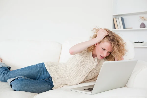Belle femme blonde se détendre avec son ordinateur portable tout en étant couché sur — Photo