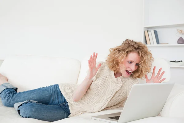 아름 다운 금발의 여 자가 그녀의 노트북에 누워 있는 동안 휴식을 — 스톡 사진