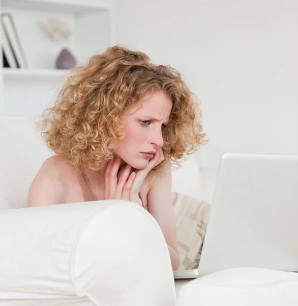 Mulher bonita loira relaxante com seu laptop enquanto sentado em um — Fotografia de Stock