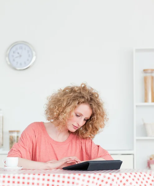 Charming blonde woman relaxing with her tablet while sitting in — Stock Photo, Image