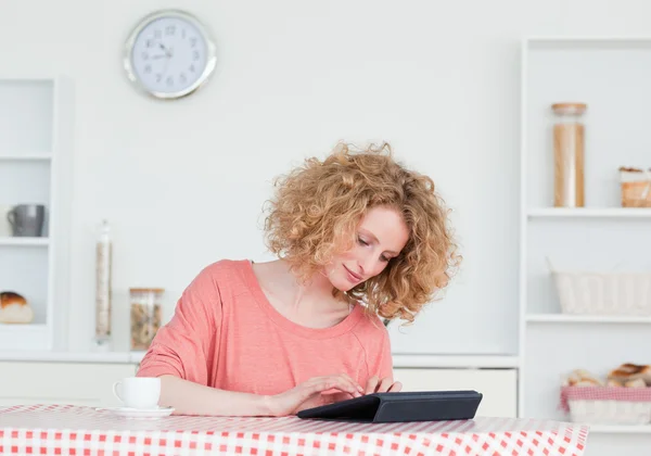 Pretty blonde woman relaxing with her tablet while sitting in th — Stock Photo, Image