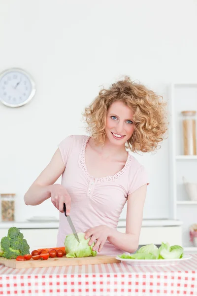 Belle femme blonde cuisinant des légumes dans la cuisine — Photo