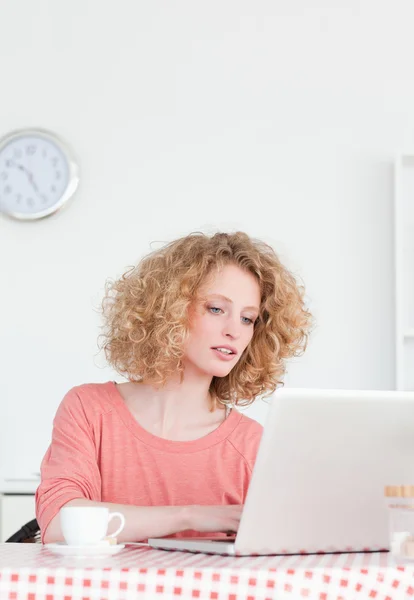Belle femme blonde se détendre avec son ordinateur portable tout en étant assis — Photo