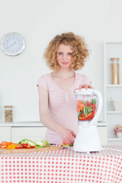 Mulher loira bonita usando um misturador na cozinha — Fotografia de Stock