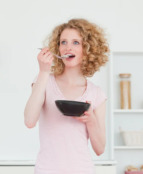 金发美女在厨房里吃一碗谷类食品 — 图库照片