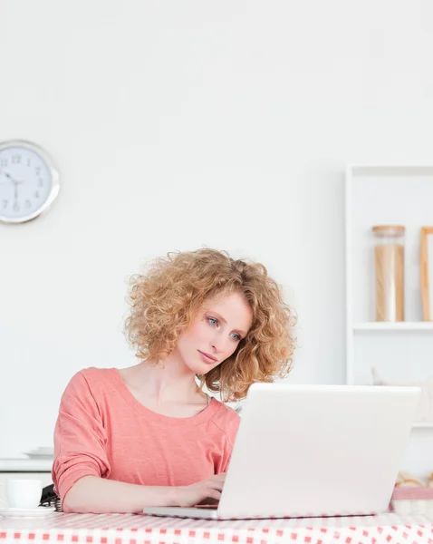 Ładny blond kobieta relaksując się przy jej laptopa siedząc w th — Zdjęcie stockowe