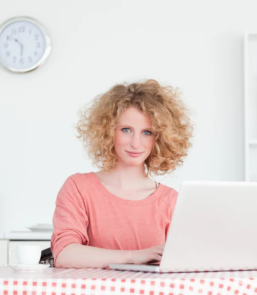 그녀의 노트북에 앉아있는 동안 편안한 화려한 금발 여자 — 스톡 사진