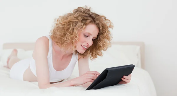 아름 다운 금발의 여 자가 그녀의 태블릿에 누워 있는 동안 휴식 한 수 — 스톡 사진