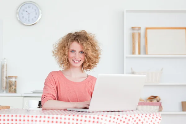 Krásná blondýnka se její laptop, zatímco sedí v th — Stock fotografie