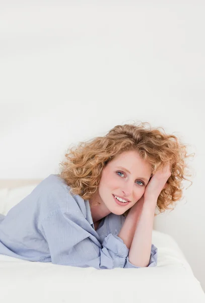 Beautiful blonde woman posing while lying on her bed — Stock Photo, Image