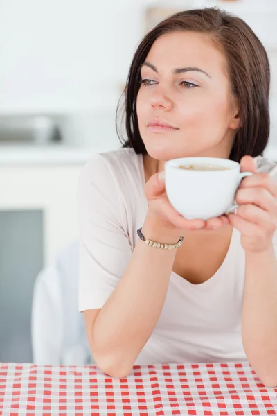 Portrait of a smiling dark-haired woman having a coffee — Stock Photo, Image
