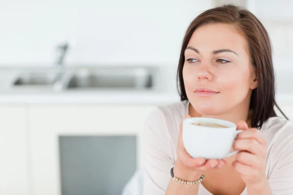 Крупным планом улыбающаяся темноволосая женщина пьет кофе — стоковое фото
