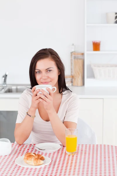 Morena sorridente tomando seu café da manhã — Fotografia de Stock
