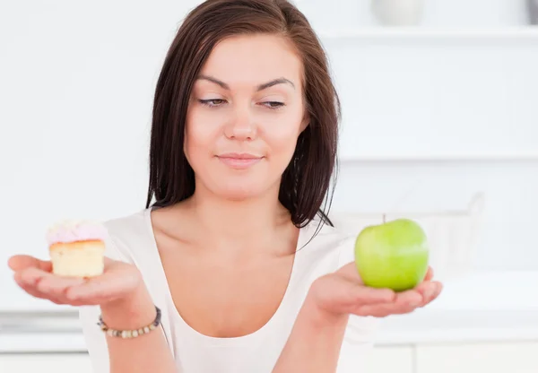Mujer linda con una manzana y un pedazo de pastel — Foto de Stock
