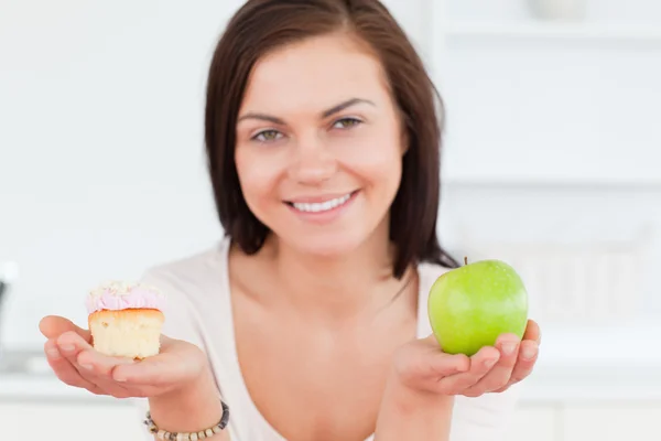 Nahaufnahme einer niedlichen Frau mit einem Apfel und einem Stück Kuchen — Stockfoto