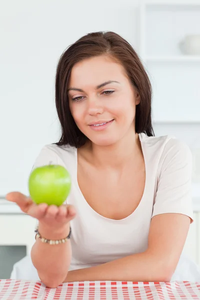 Usměvavá brunetka ukazuje apple — Stock fotografie