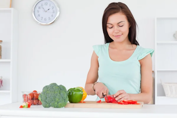 Cute woman slicing a pepper — Stock Photo, Image