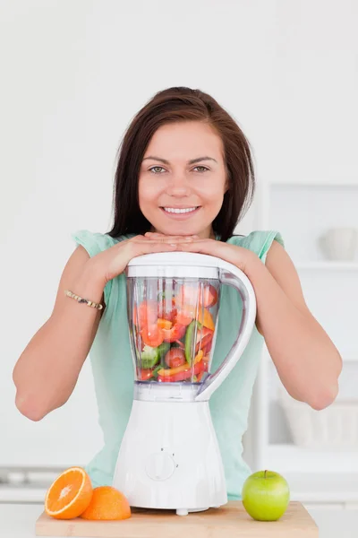 Lächelnde junge Frau posiert mit einem Mixer — Stockfoto