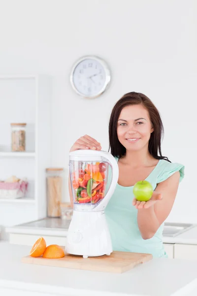 Cute woman with a blender and an apple — Stock Photo, Image