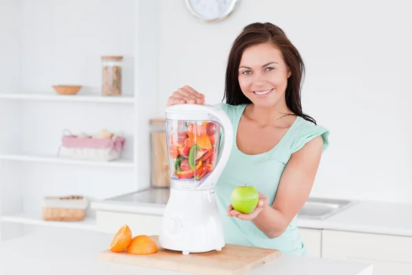 Happy woman with a blender and an apple — Stock Photo, Image