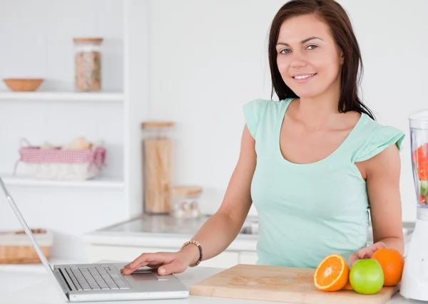 ノート パソコンや果物を持つ女性 — ストック写真