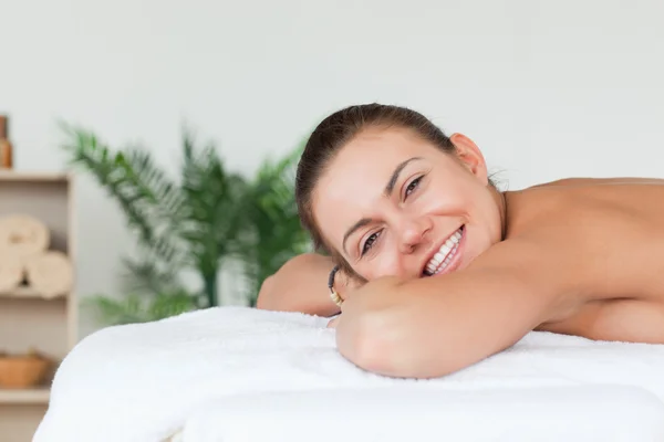 Morena sorridente esperando por uma massagem — Fotografia de Stock