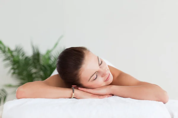 Young brunette lying on a massage table in a spa — Stock Photo, Image