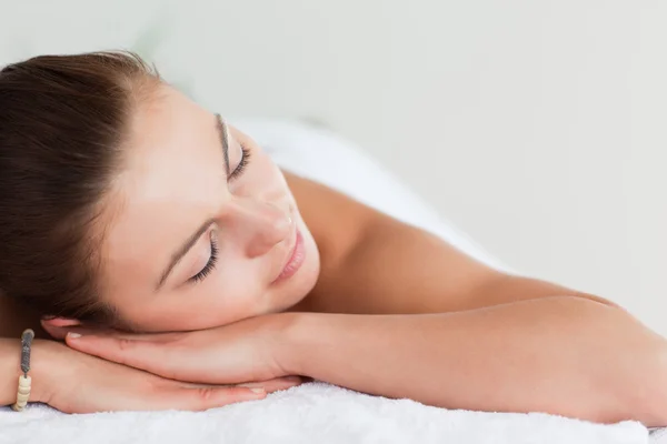 Närbild på en ung brunett liggande på en massagebänk — Stockfoto